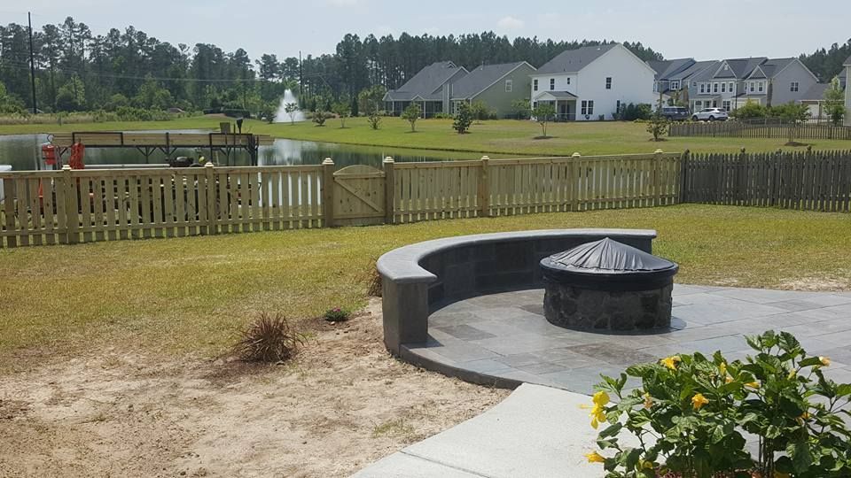 A backyard with a fire pit and a wooden fence