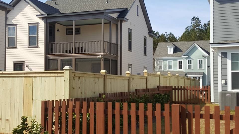 A row of houses with a wooden fence in front of them