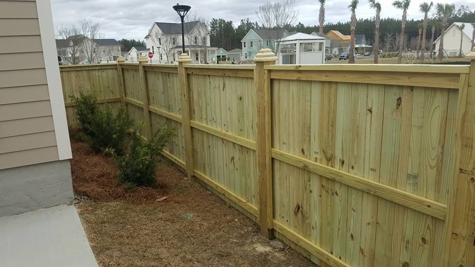 A wooden fence is sitting in front of a house.