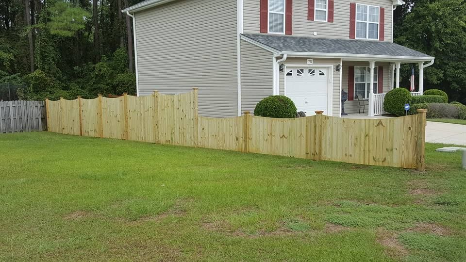 A house with a wooden fence in front of it.