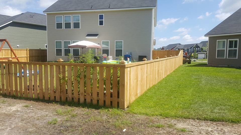 There is a wooden fence in the backyard of a house.