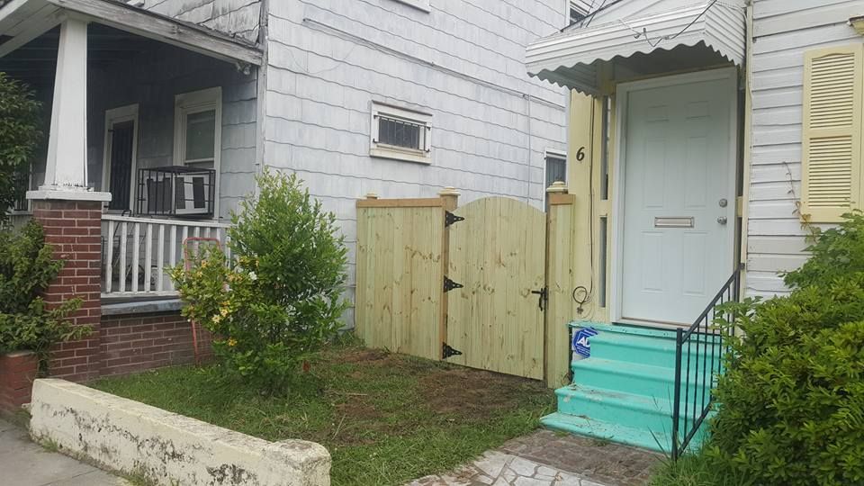 A white house with a wooden fence in front of it.