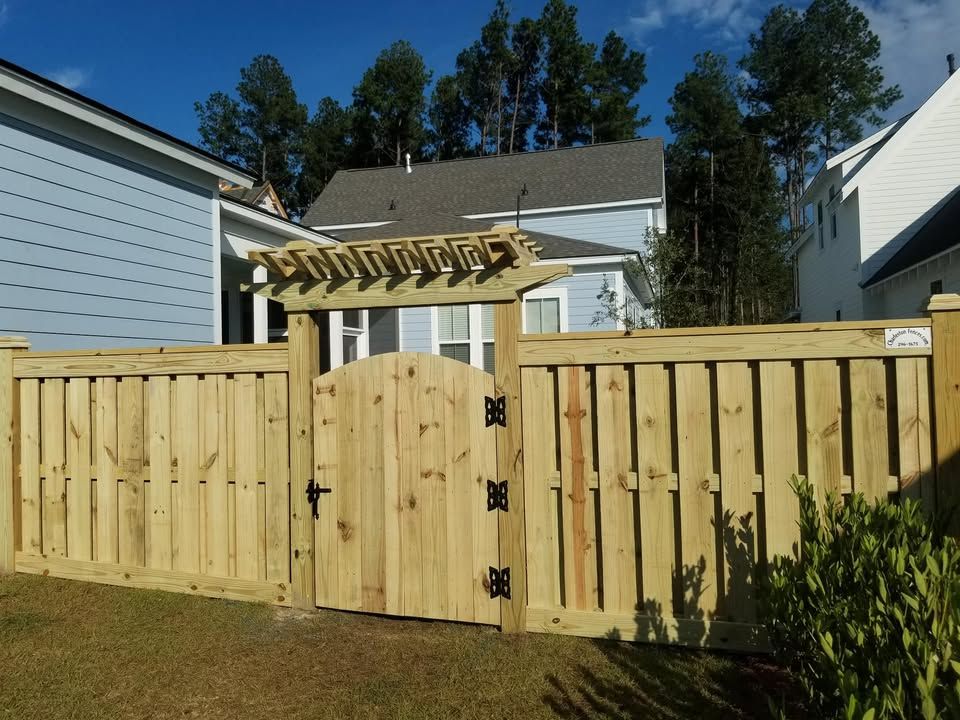 A wooden fence with a gate in front of a house