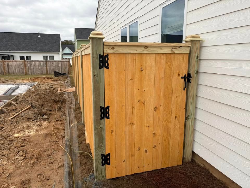 A wooden fence is sitting next to a house.