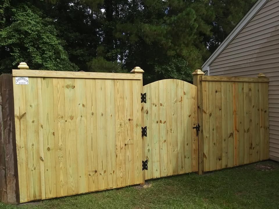 A wooden fence with a gate in front of a house