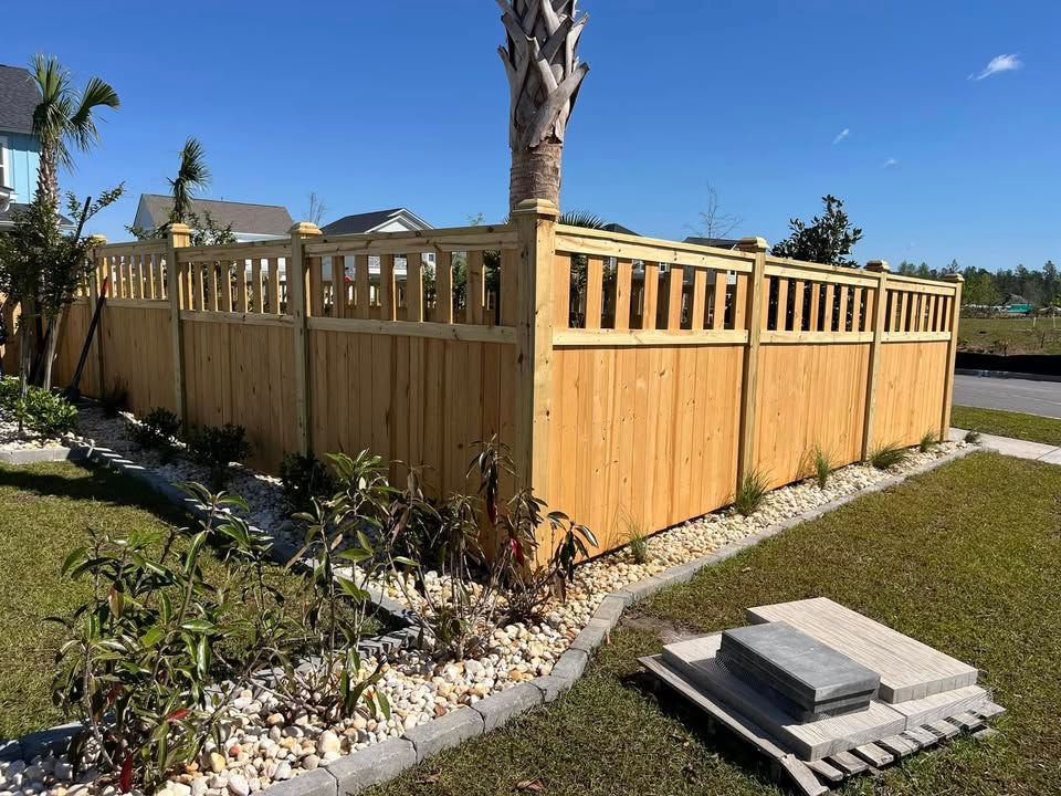 A wooden fence is sitting in the middle of a lush green yard.