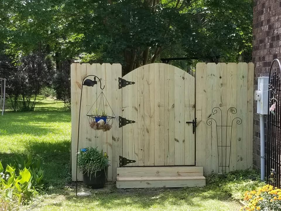 A wooden fence with a gate in the middle of it
