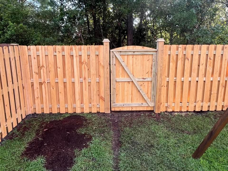 A wooden fence with a gate in the middle of it.