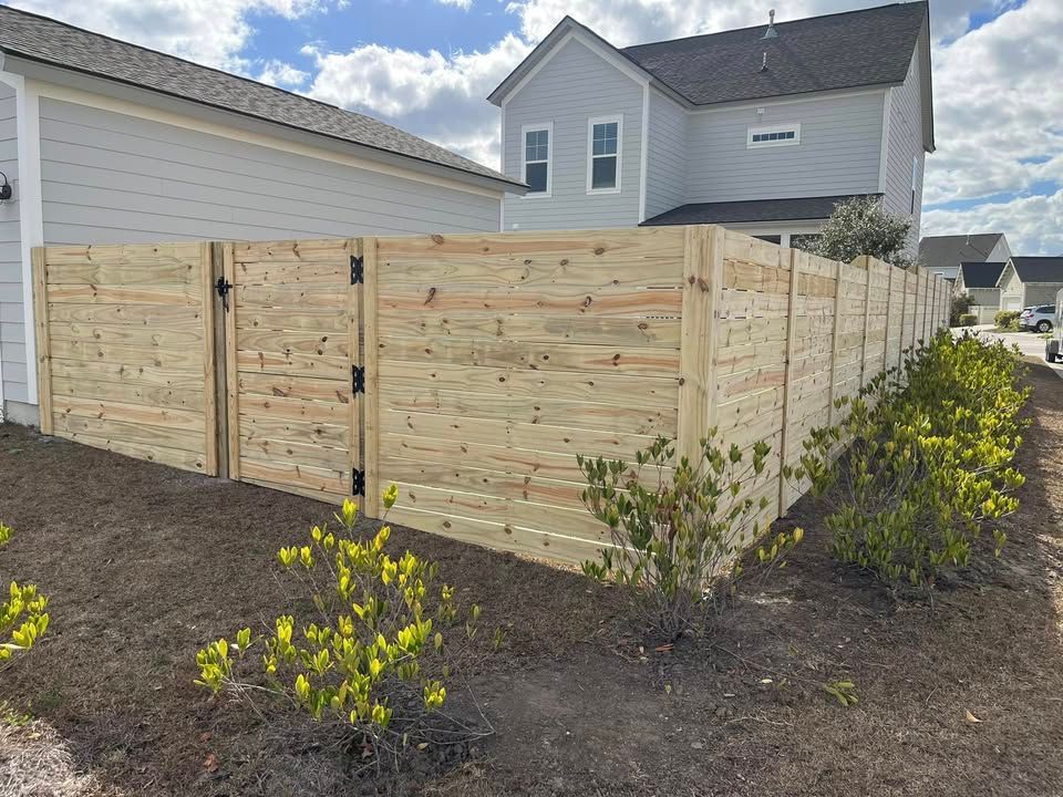 A wooden fence is sitting in front of a house.