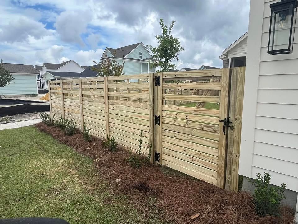 A wooden fence with a gate in front of a house.
