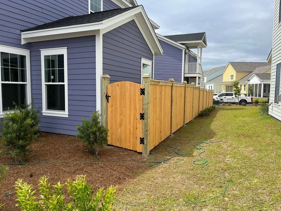 A wooden fence is in front of a purple house.