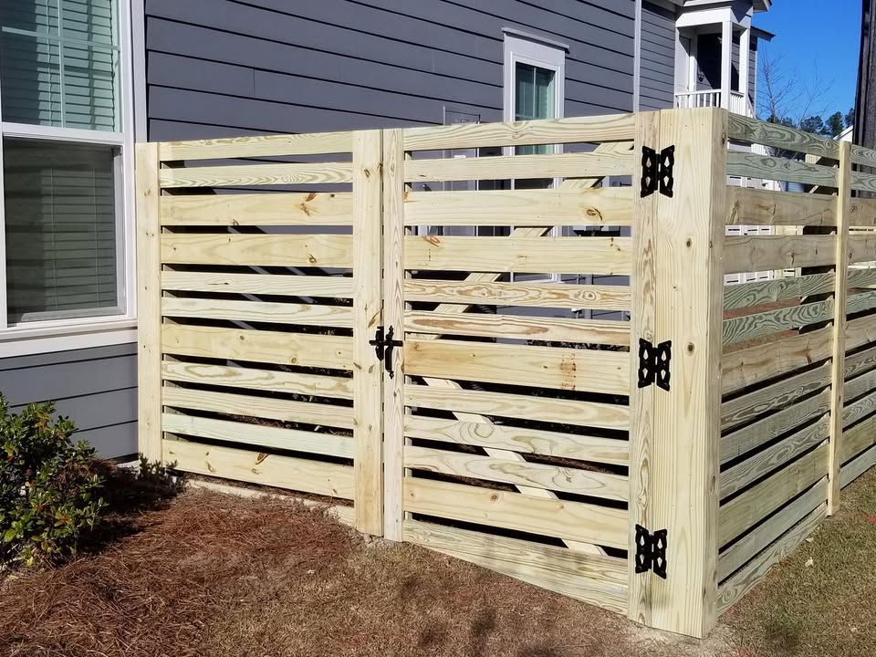 A wooden fence with a gate in front of a house.