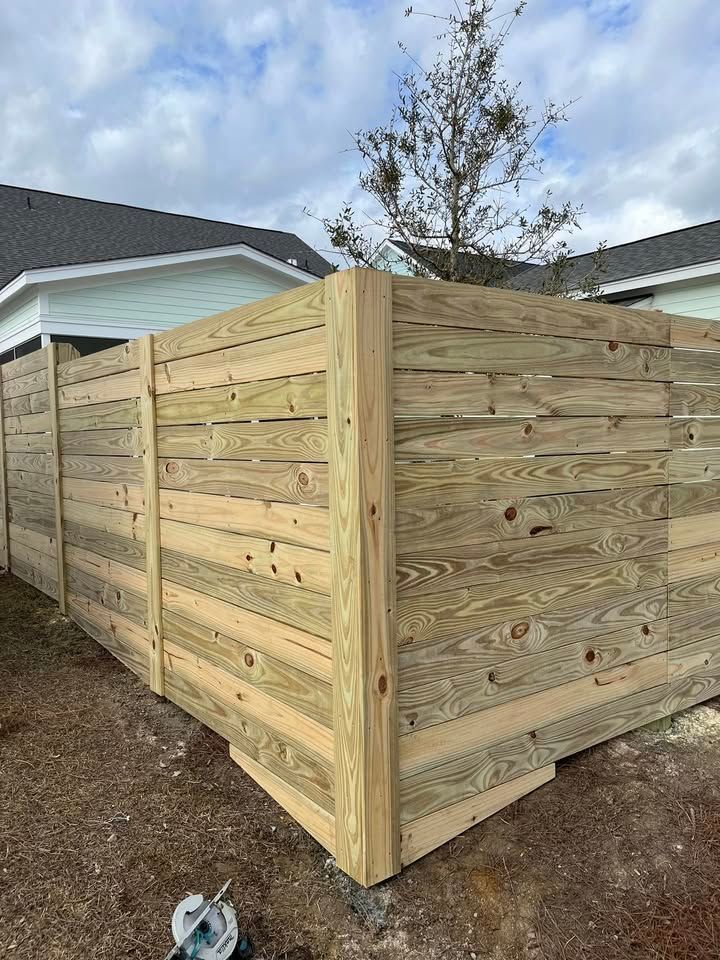 A wooden fence is being built in front of a house.