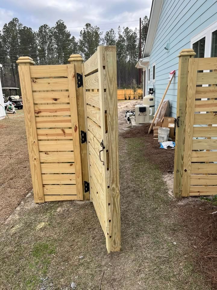 A wooden fence is being built in front of a house.