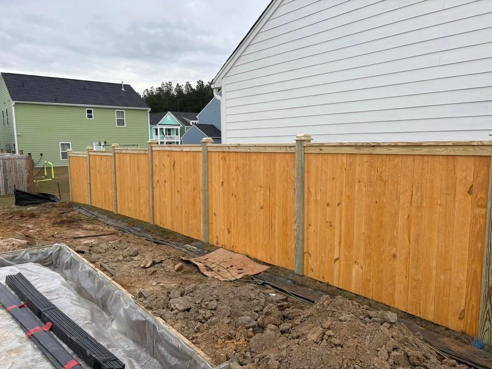 A wooden fence is being built in front of a house.