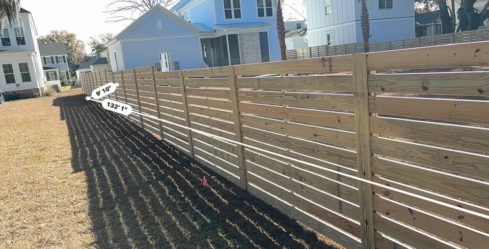 A wooden fence with a blue house in the background