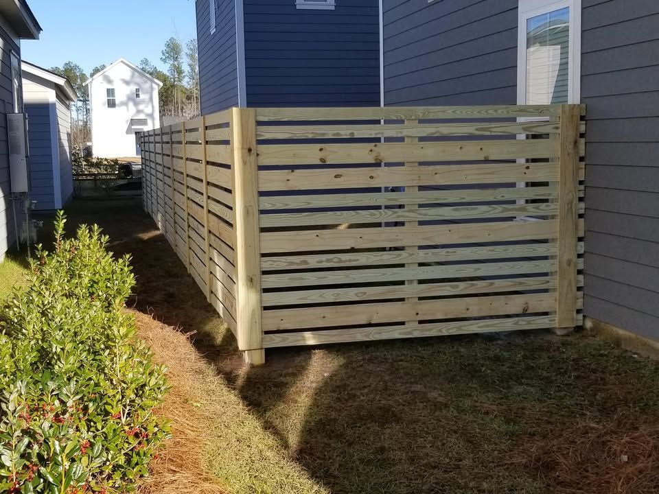 A wooden fence is sitting next to a house.