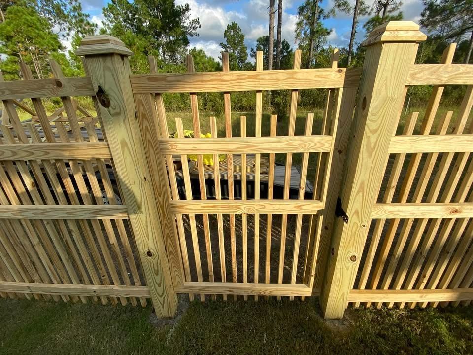 A wooden fence with a gate in the middle of it.