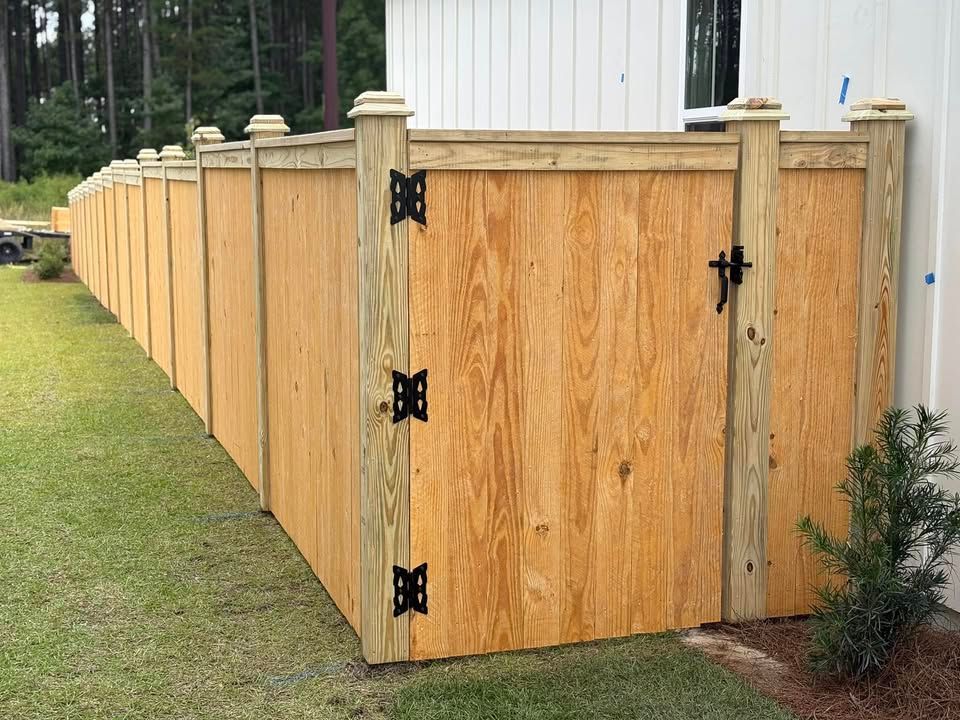 A wooden fence with a gate in the backyard of a house.