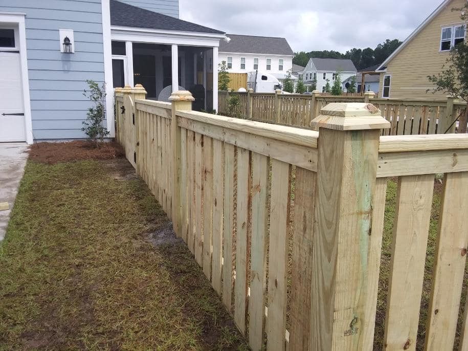 A wooden fence is in front of a house