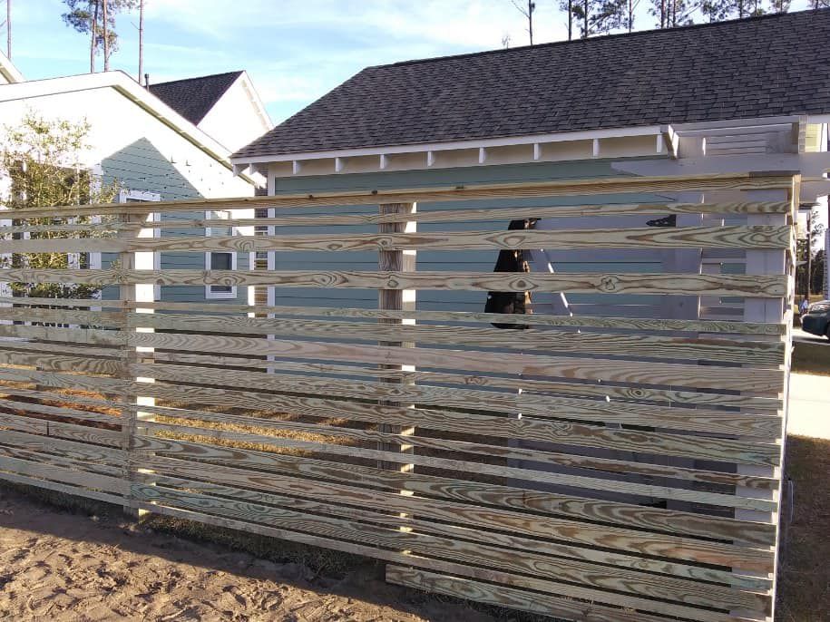 A wooden fence is being built in front of a house.