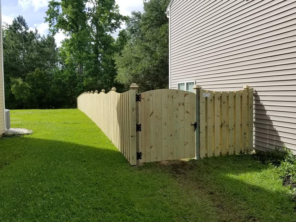 A wooden fence with a gate in the backyard of a house.