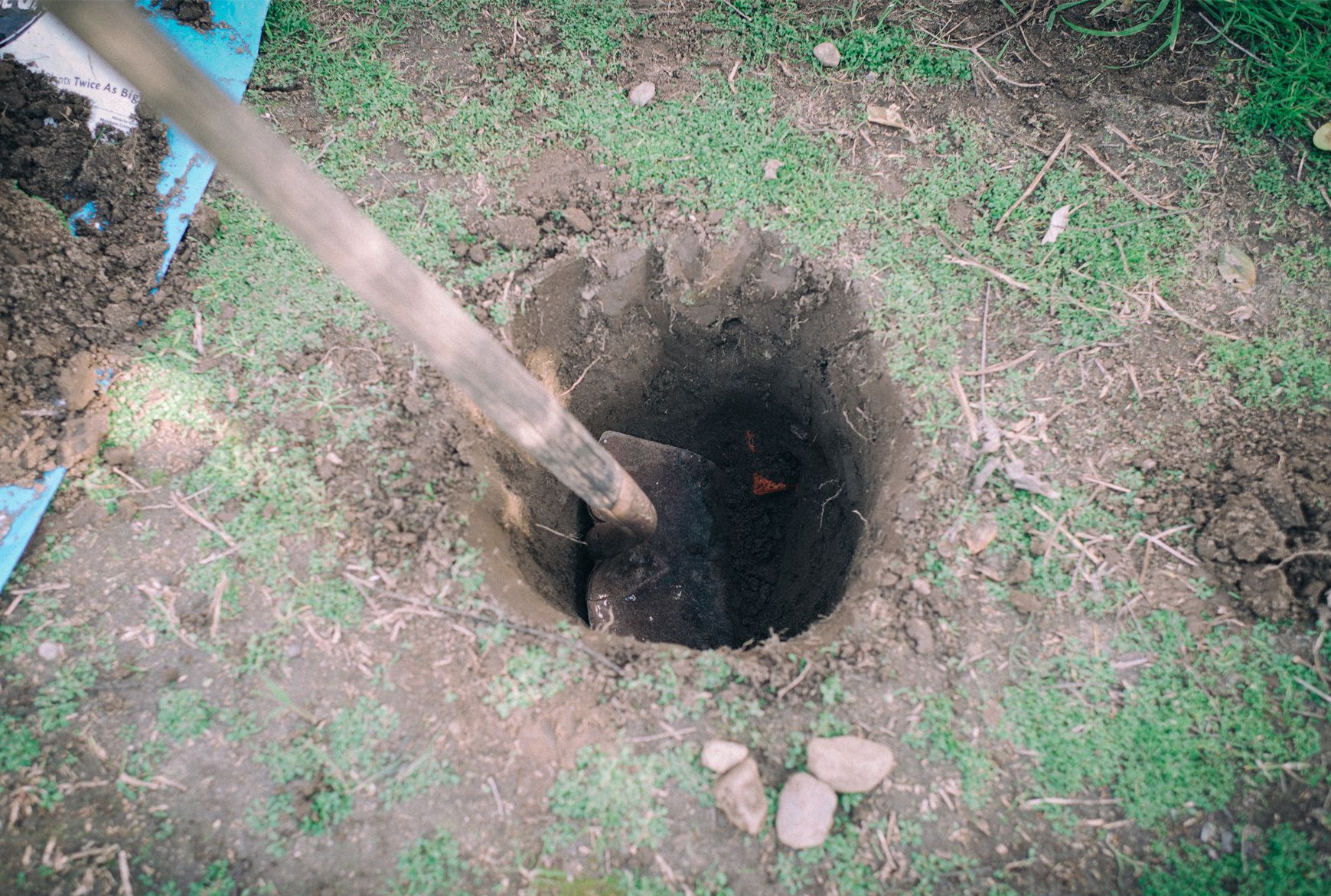 A person is digging a hole in the ground with a shovel.