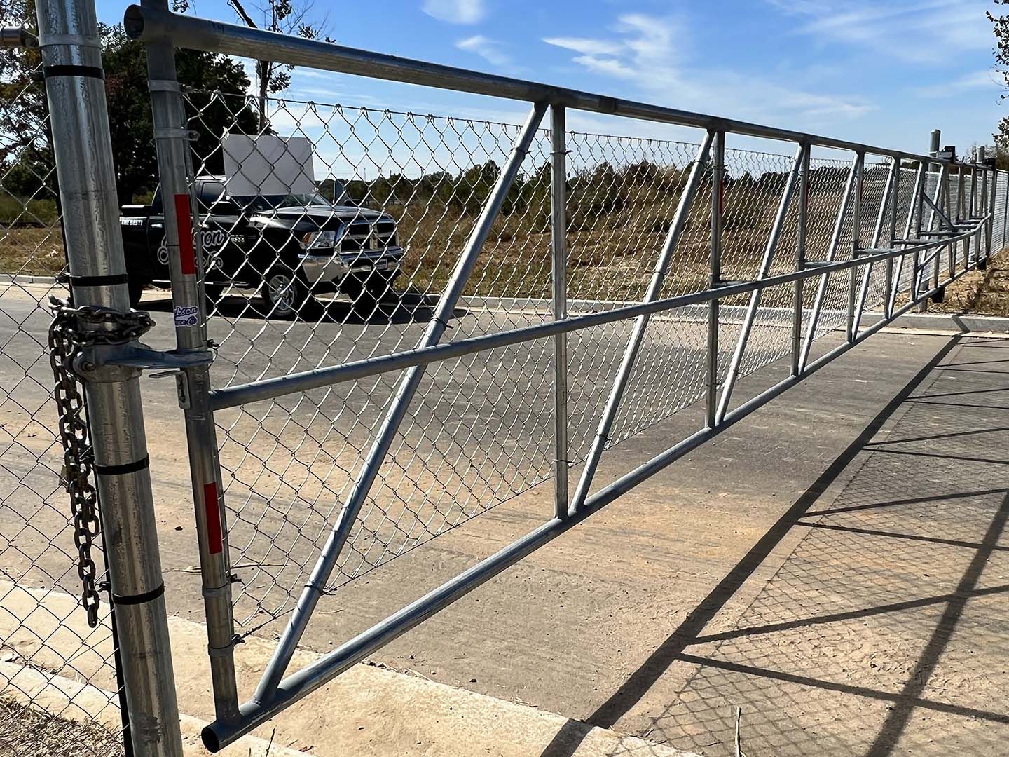A chain link fence with a truck parked behind it.