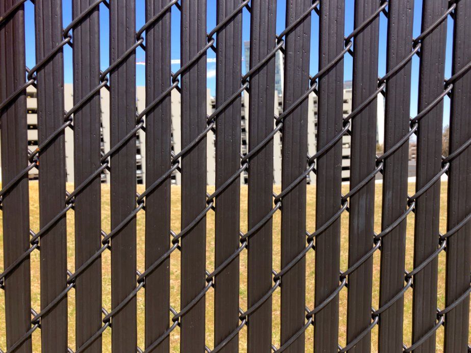 A close up of a chain link fence with a blue sky in the background