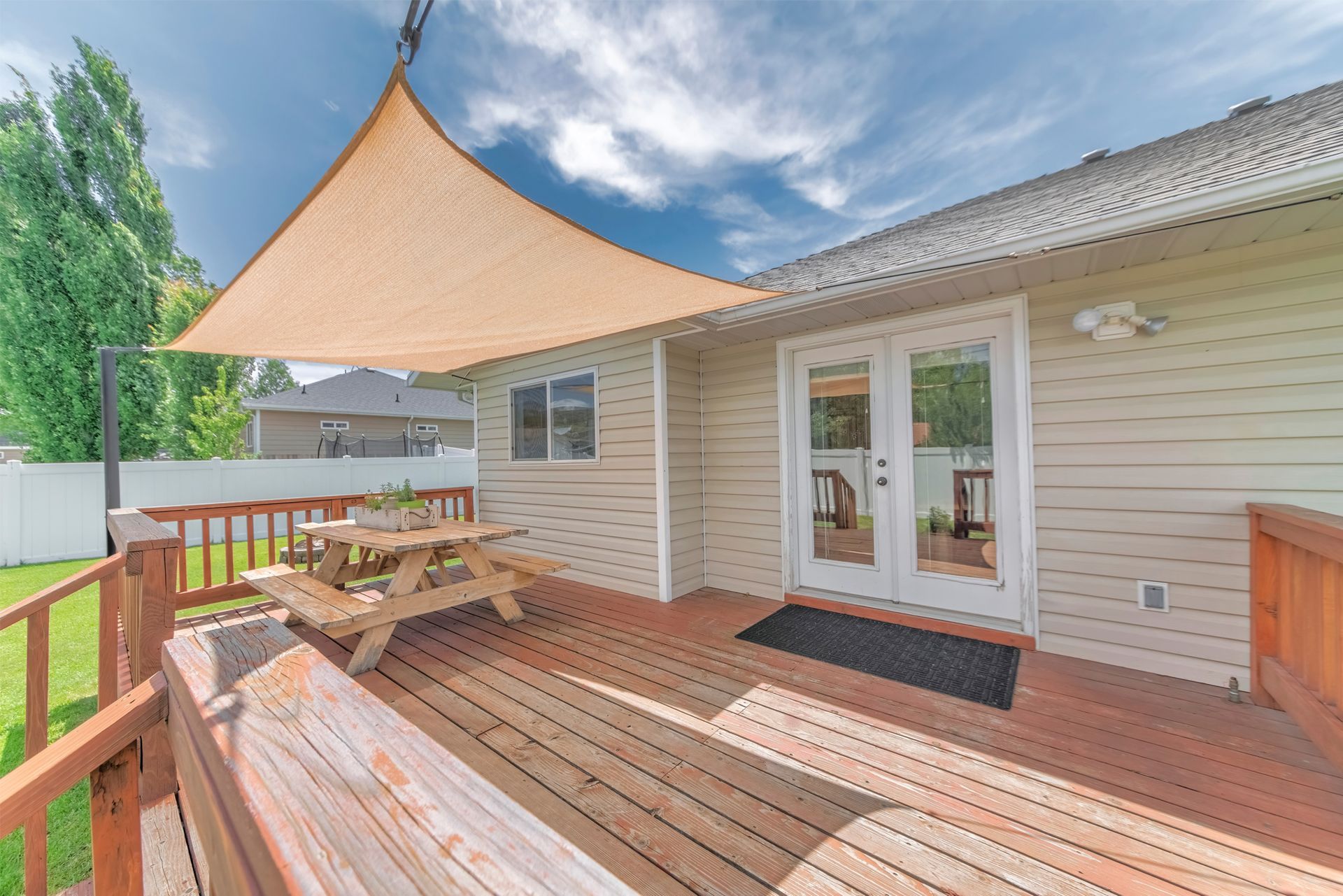 There is a picnic table on the deck of a house.
