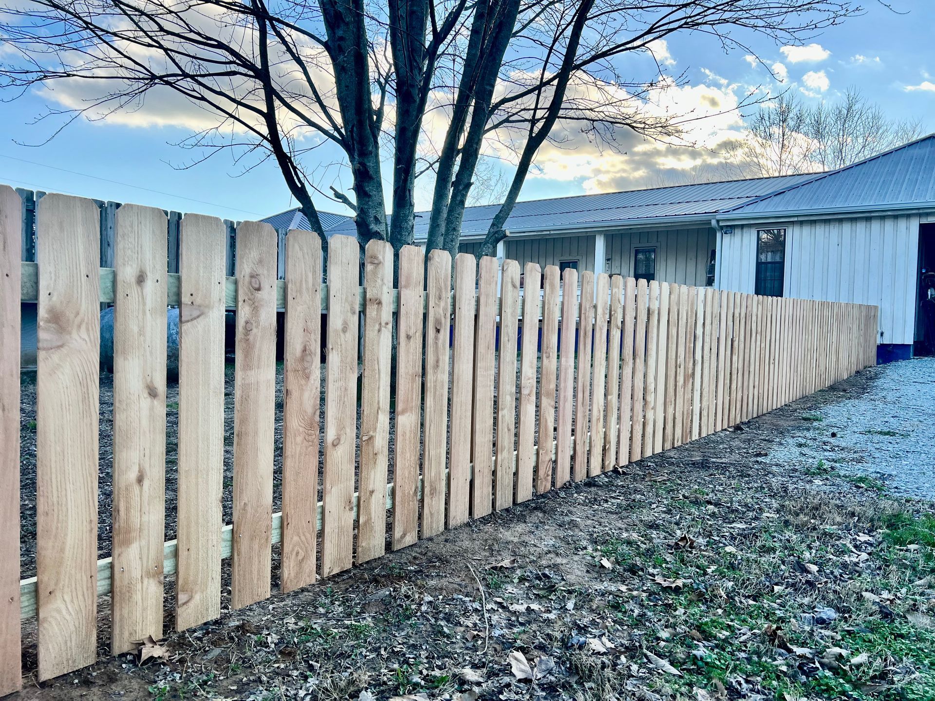 A wooden fence is sitting in front of a house.