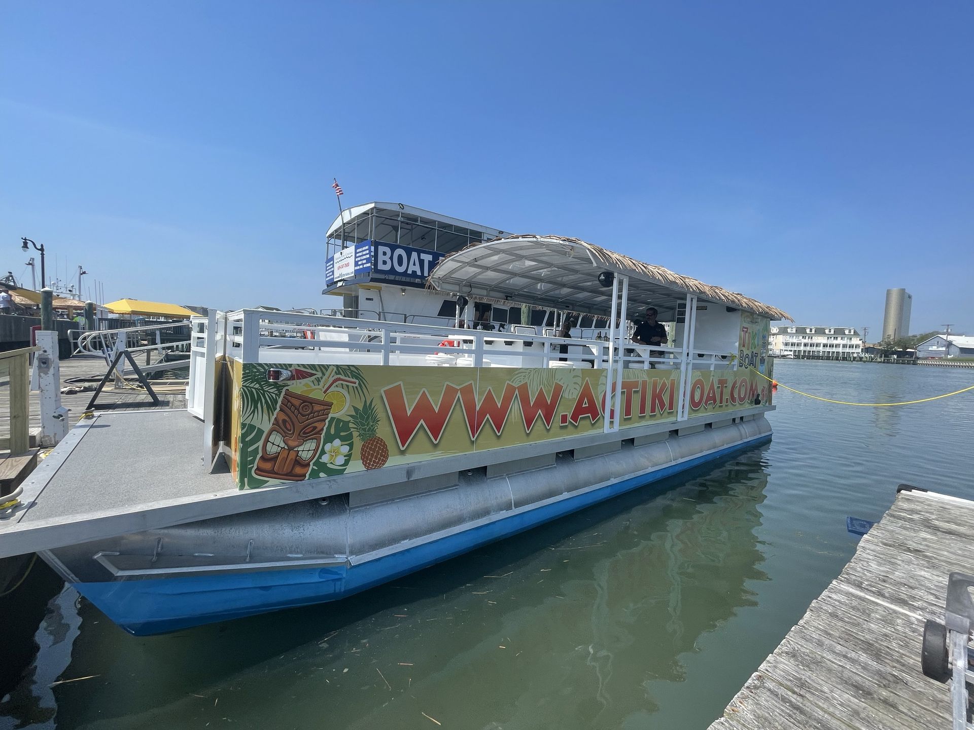 Tiki boat docked at a pier, blue and white with 