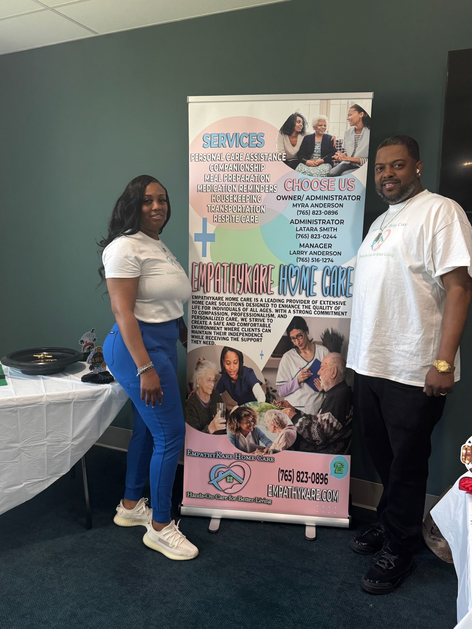 Two people stand by a banner