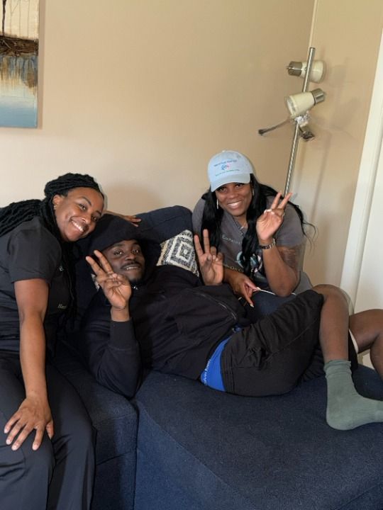 Three people on a blue couch, making peace signs