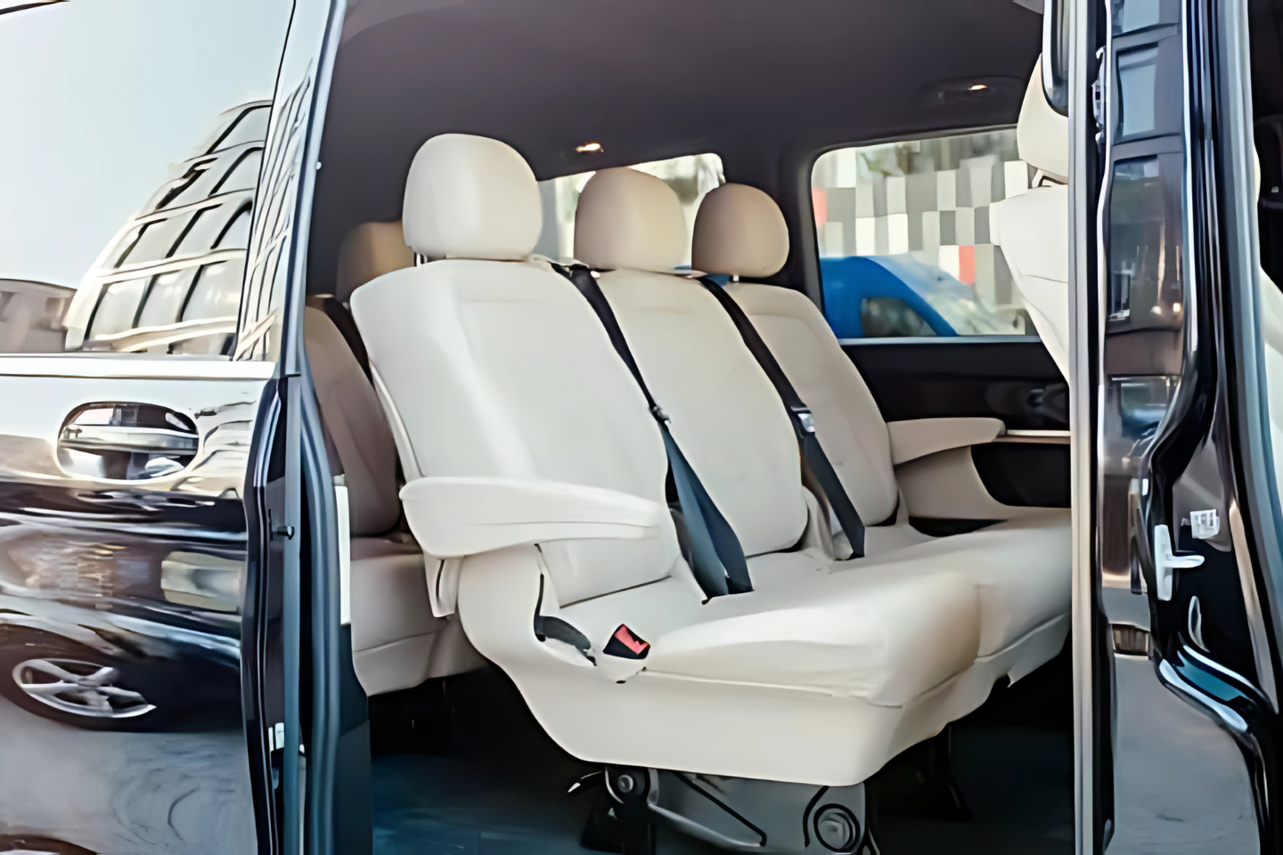 Premium cream-leather interior of an Athenaos luxury Mercedes van with sliding door open.