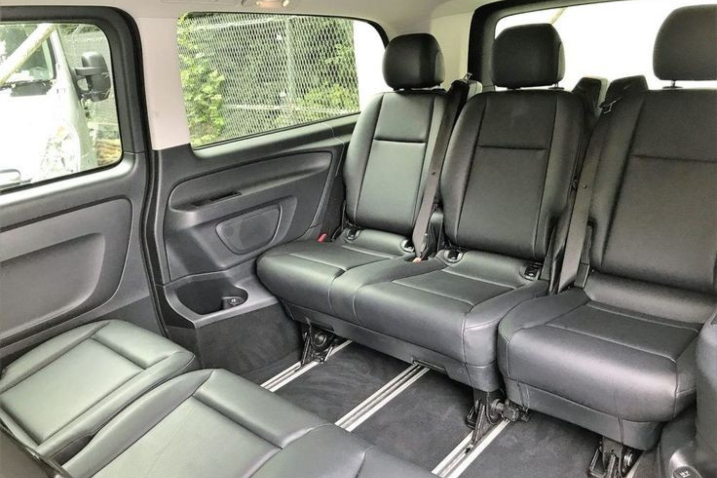 Interior seating layout of an Athenaos Mercedes van showing spacious leather seats.