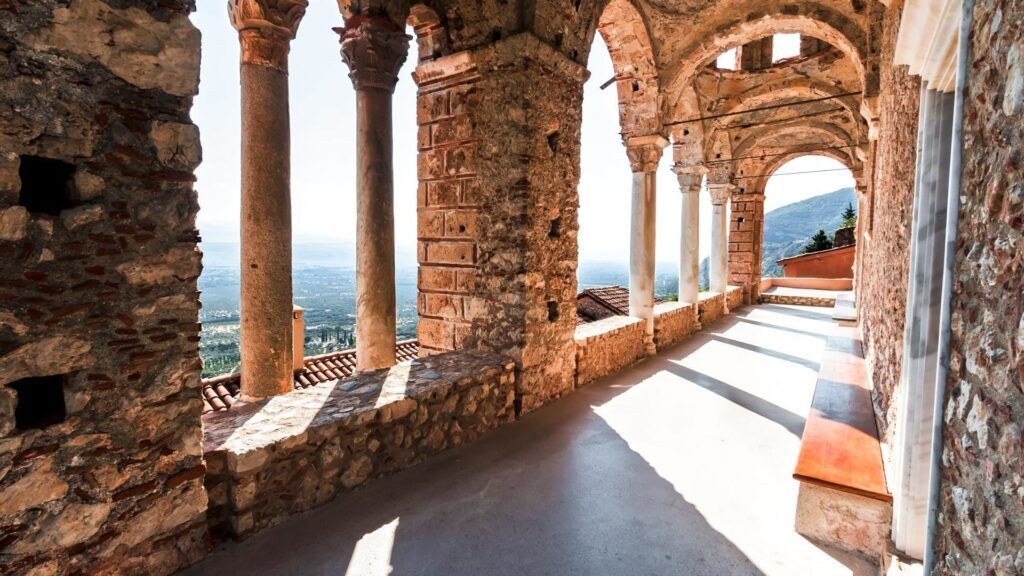 Arched corridor with stone columns at Mystras Monastery