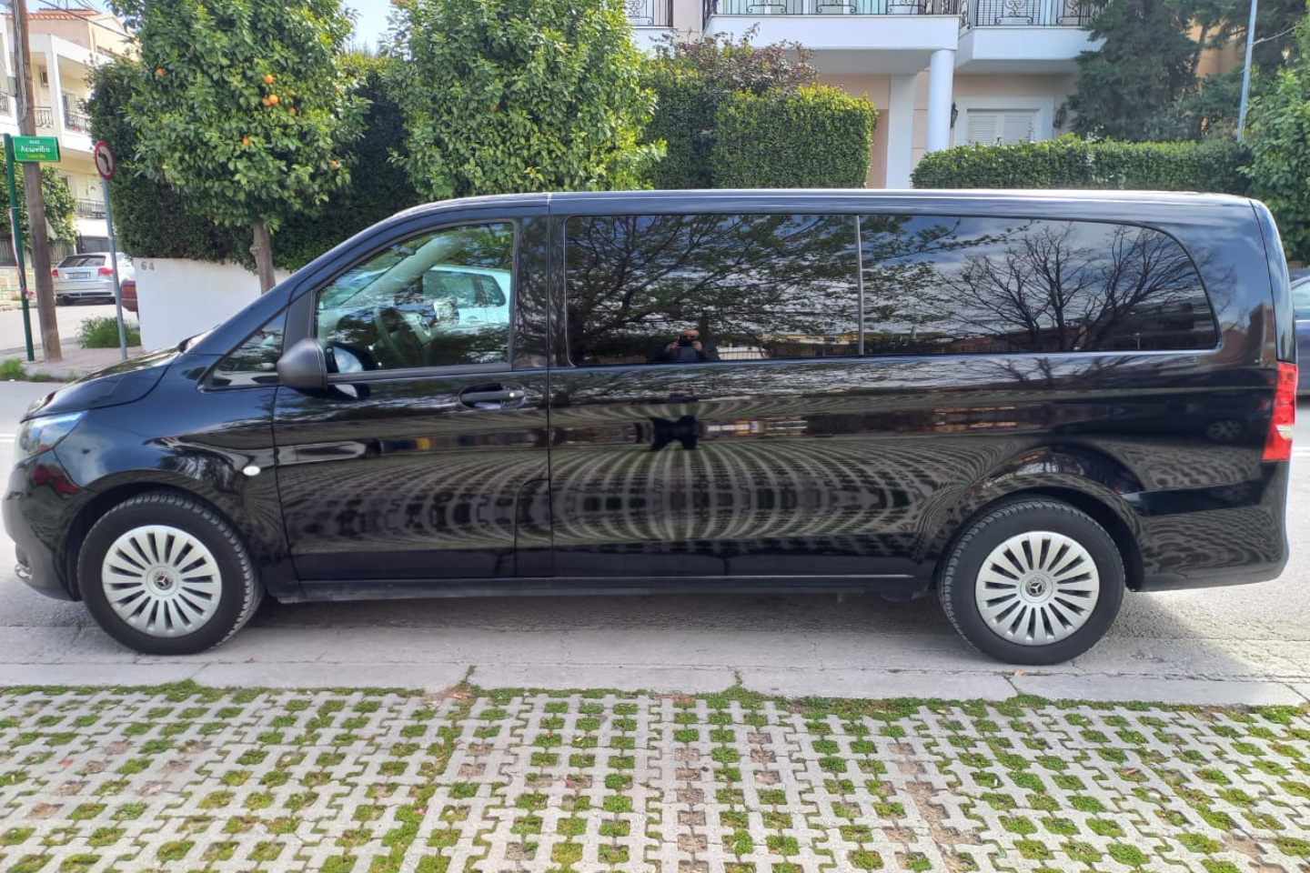 Side view of an Athenaos black Mercedes van in a residential area.