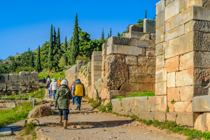 Visitors walking through the archaeological site of Delphi