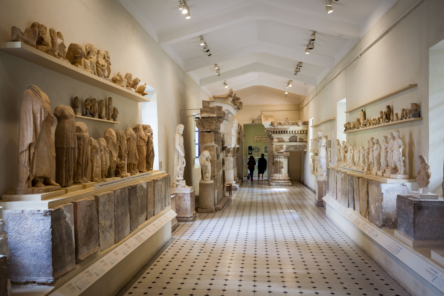 Archaeological museum gallery with marble statues and ancient artifacts at Olympia