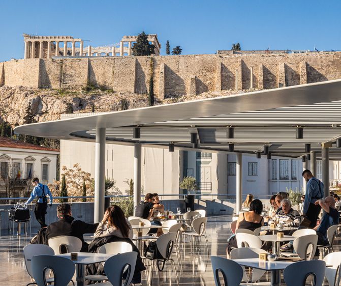 Visitors enjoying the rooftop café at the Acropolis Museum with a clear view of the Acropolis