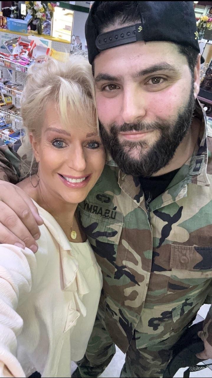 A man in a military uniform is posing for a picture with a woman.