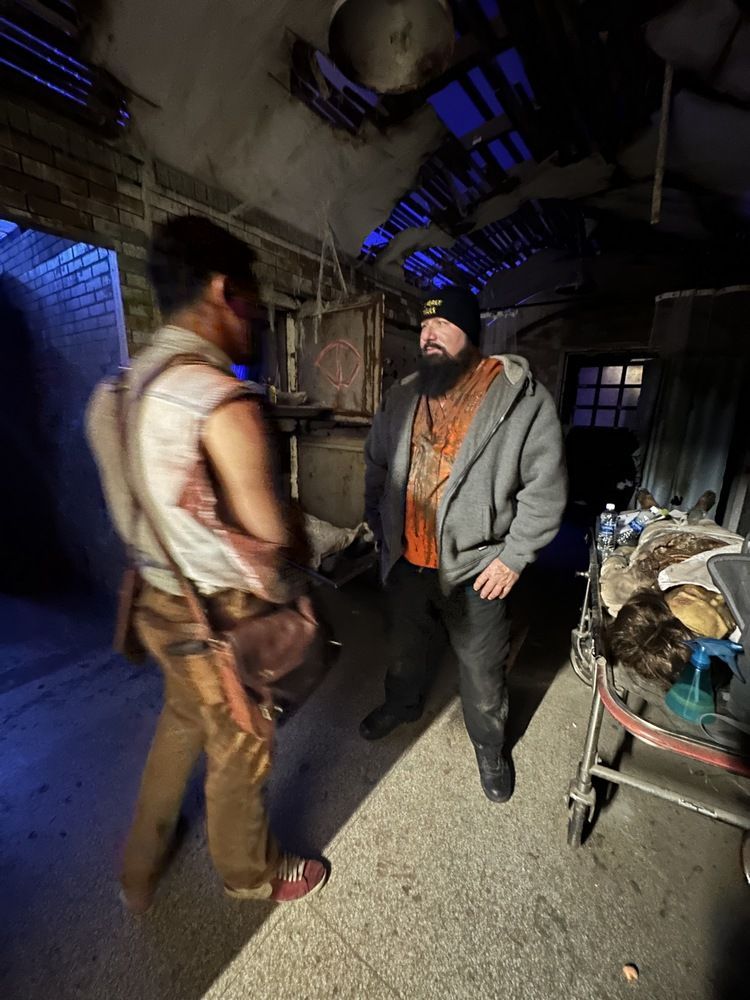 Two men are standing next to each other in a dark room.