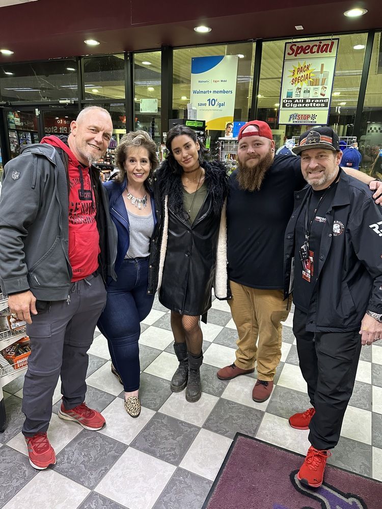 A group of people are posing for a picture in front of a store.