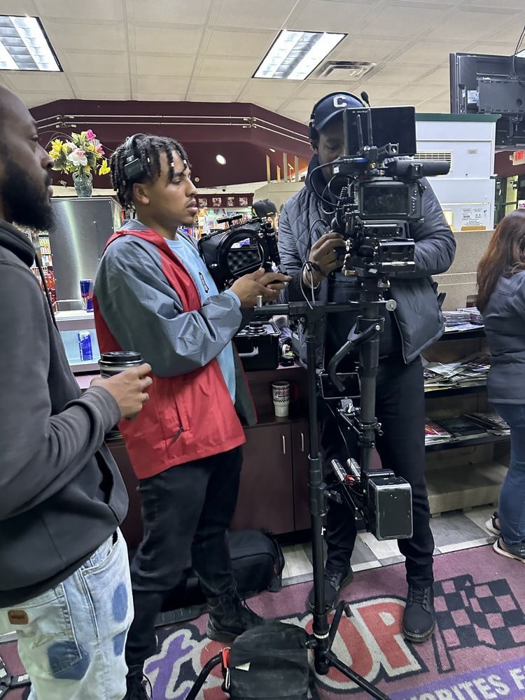 A group of people are standing around a camera in a store.