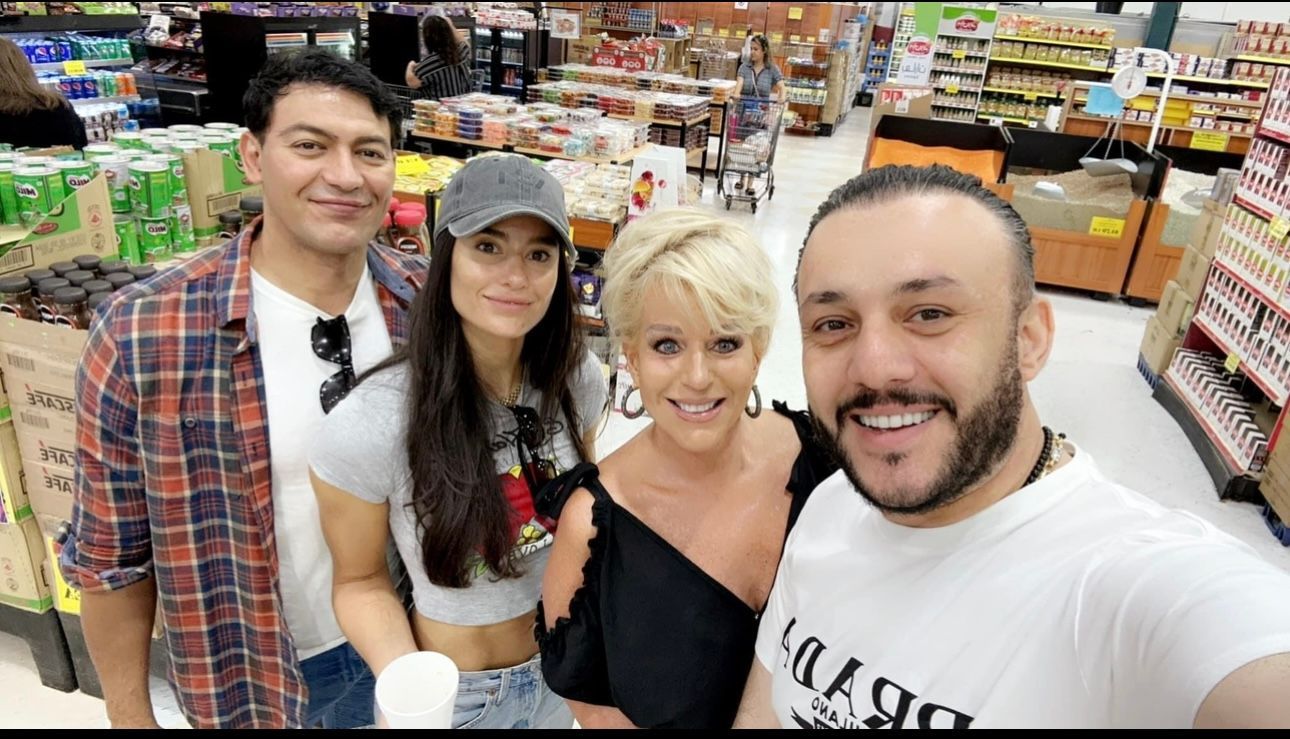 A group of people are posing for a picture in a grocery store.