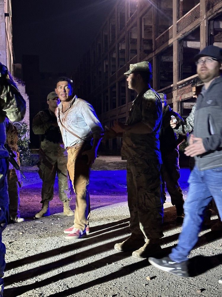 A group of people are standing in front of a building at night.