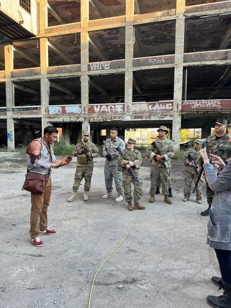 A group of soldiers are standing in front of an abandoned building.