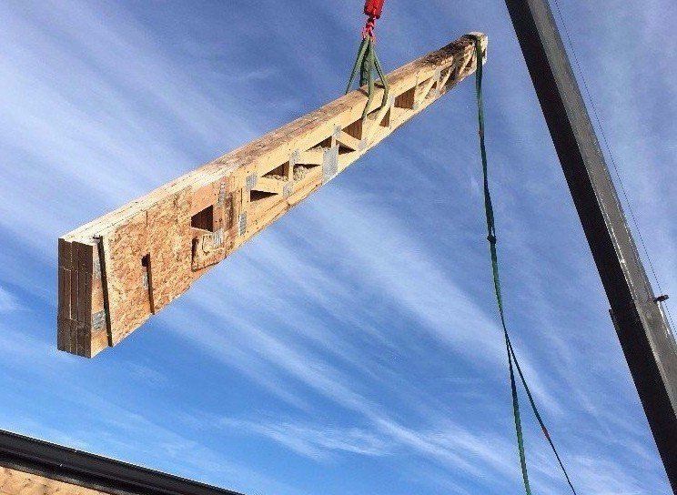 New roof truss delivered by crane to rooftop in Lakeview, Chicago