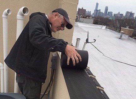 Bob Kelly installs WickRight Vapor Permeable Membrane on parapet, Chicago
